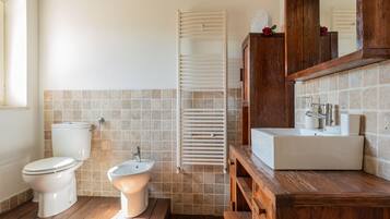 Un bagno con toilette, bidet e lavandino.