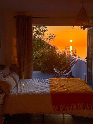 A bedroom with a bed, a window, and a view of the sunset. - Seawood Villa • Devon • SeaViews • Beachfront (Combe Martin)