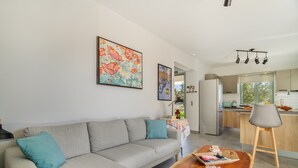 Una sala de estar moderna con un sofá, una mesa de centro y obras de arte en la pared.