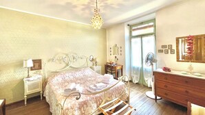 Um quarto com cama, penteadeira, mesa de cabeceira, espelho e ventilador de teto.