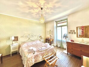 Ein Schlafzimmer mit Bett, Kommode, Schminktisch und Deckenventilator.