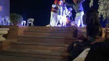 Une scène où des artistes se produisent, entourée de sièges en plein air et d’escaliers.