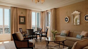 Ein helles Wohnzimmer mit einer Couch, Sesseln, einem Couchtisch und einem Chandelier.