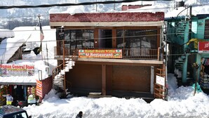 A two-story building with a sign for Hotel Rosh Villa & Restaurant. - Hotel Rosh Villa (Manali)