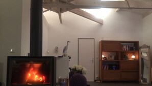 Ett vardagsrum med en öppen spis, en bokhylla och en dörr.