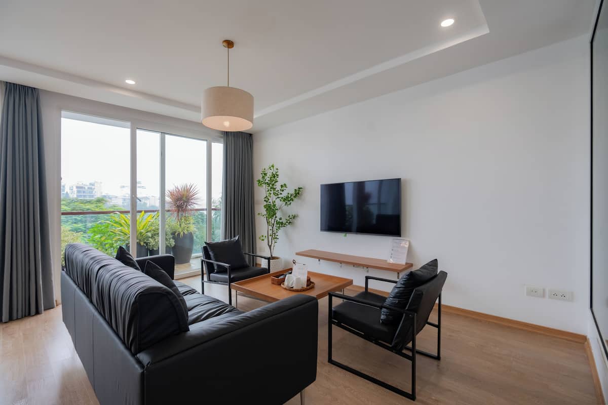 Una sala de estar moderna con un sofá, sillones, una mesa de centro y un televisor.