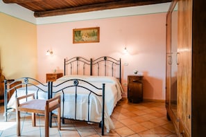 A bedroom with a bed, wooden chair, nightstands, and a wardrobe.