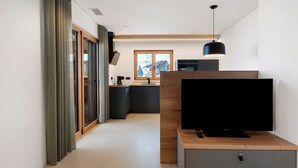 Eine moderne Küche mit großem Fenster, Flachbildfernseher und Pendelleuchte.