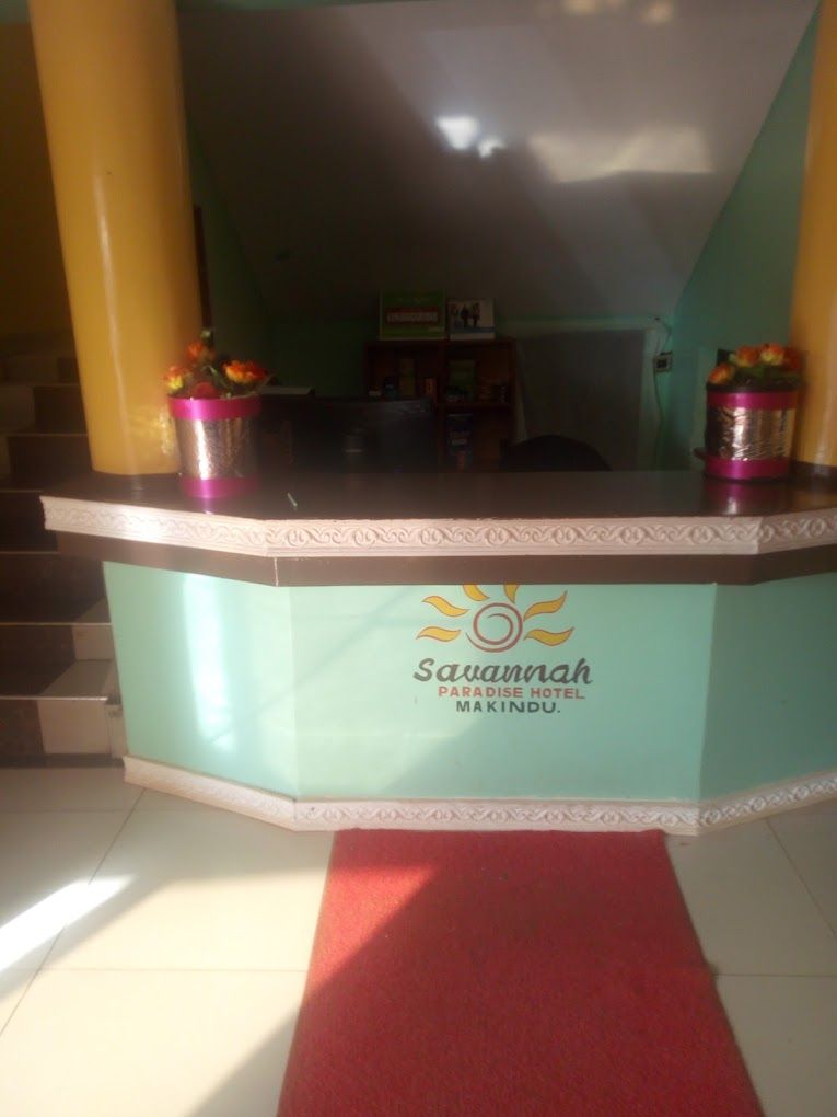 Een receptiebalie bij Savannah Paradise Hotel Makindu, met een trap op de achtergrond.