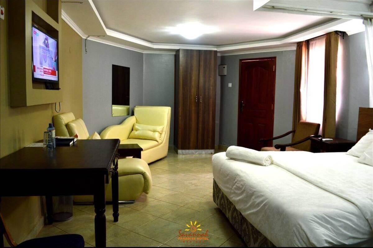 Une chambre d’hôtel équipée d’un lit, d’un bureau, d’une chaise, d’une télévision et d’une armoire.