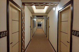 A hotel corridor with doors numbered 401 and 409, leading to rooms.