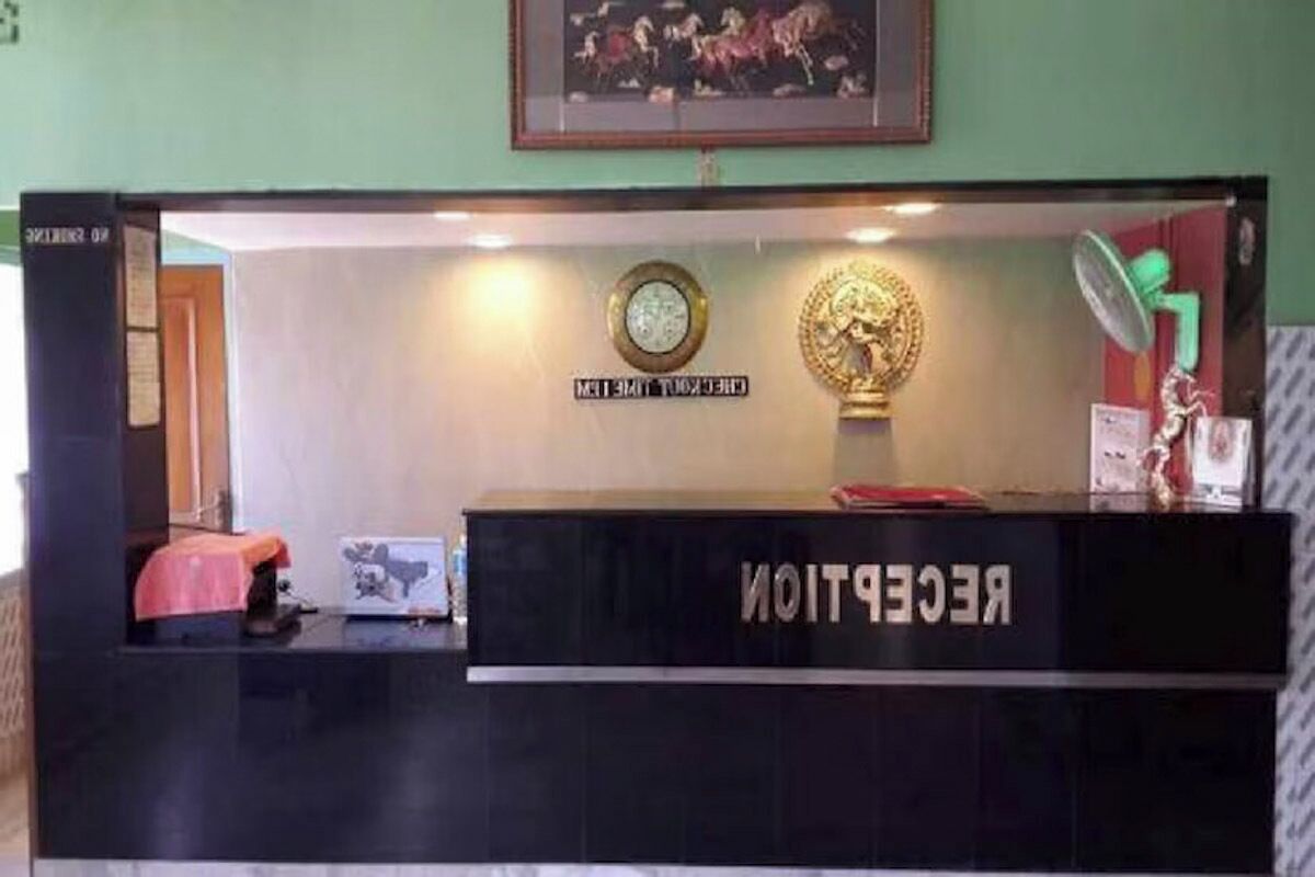 A reception desk with a clock, a framed picture, and a statue.