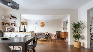 Un espacio habitable moderno con comedor, sofá y mesa de centro.