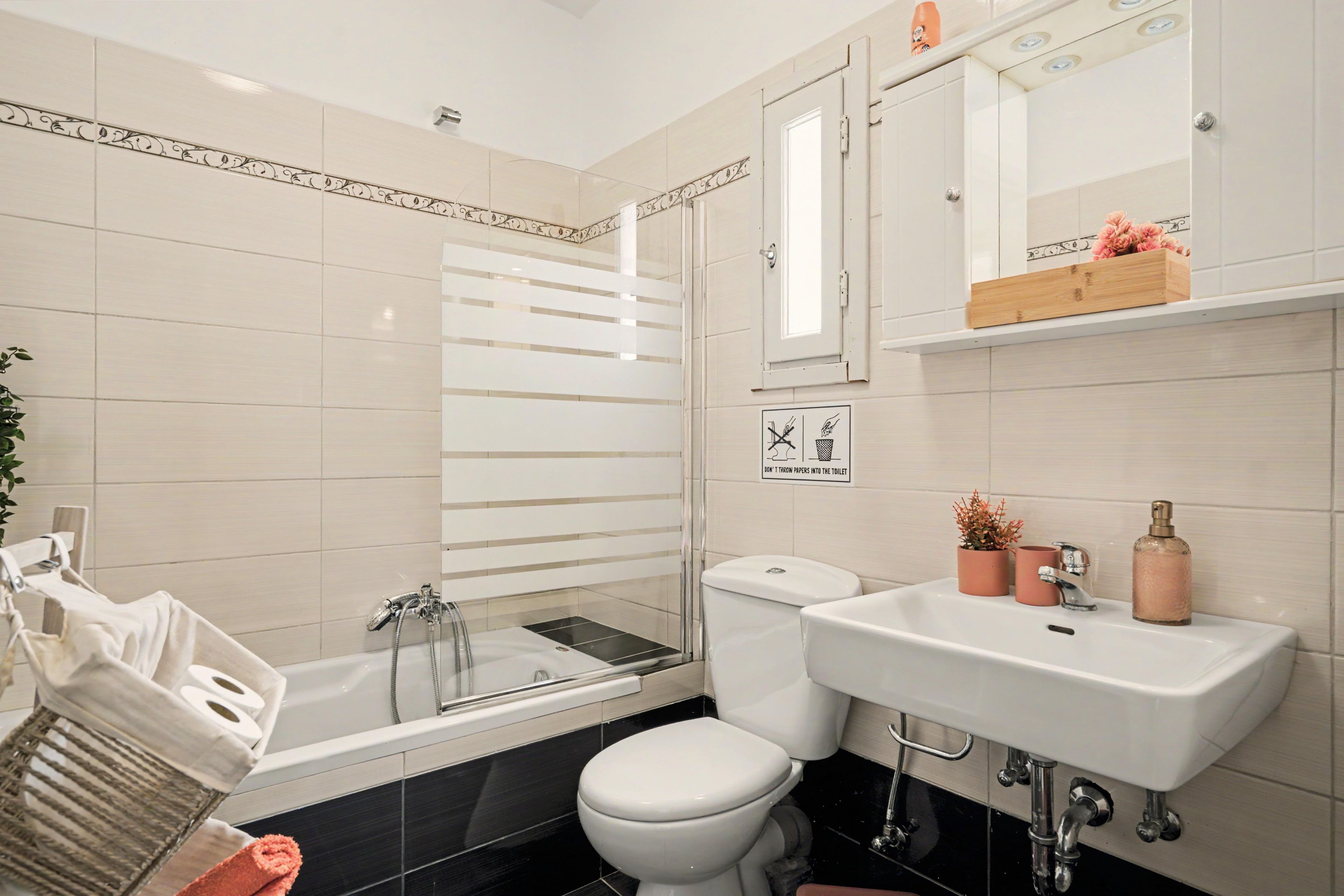 A modern bathroom with a bathtub, toilet, and sink.