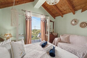 Una camera da letto con un letto, una cassettiera, uno specchio e un balcone con tende.