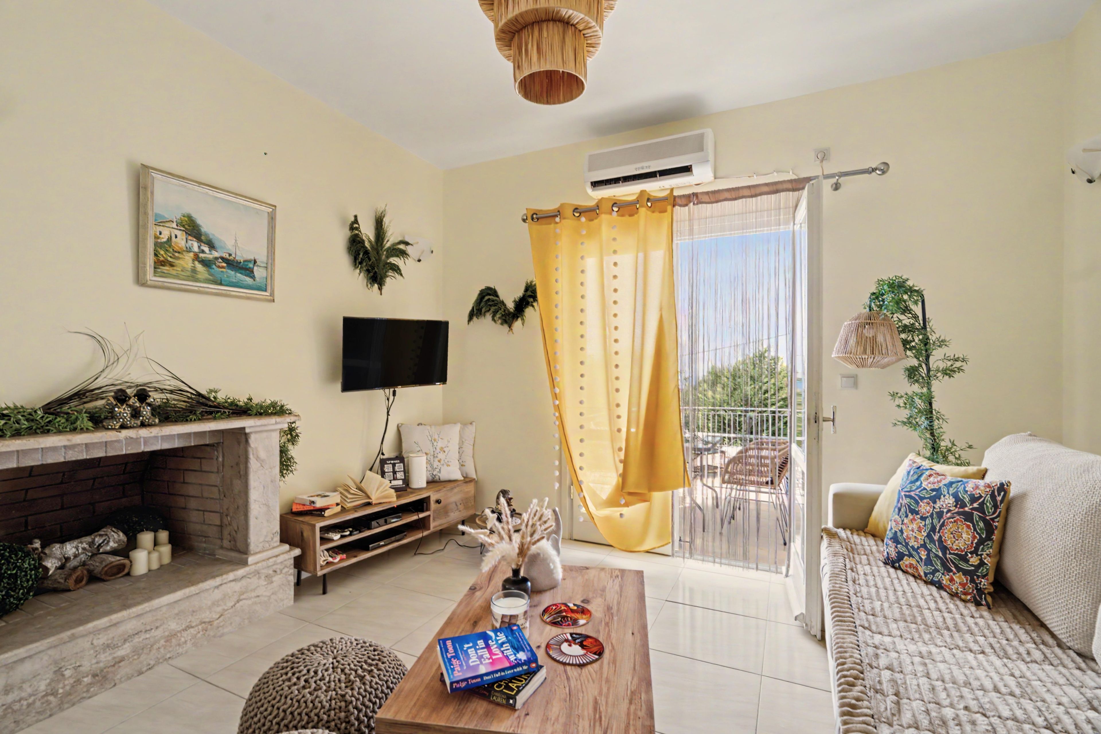A living room with a fireplace, a television, a sofa, and a dining area with a table.