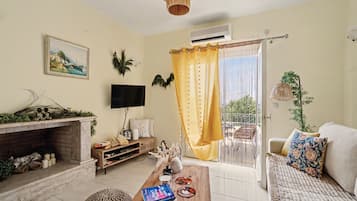 A living room with a fireplace, a television, a sofa, and a dining area with a table.