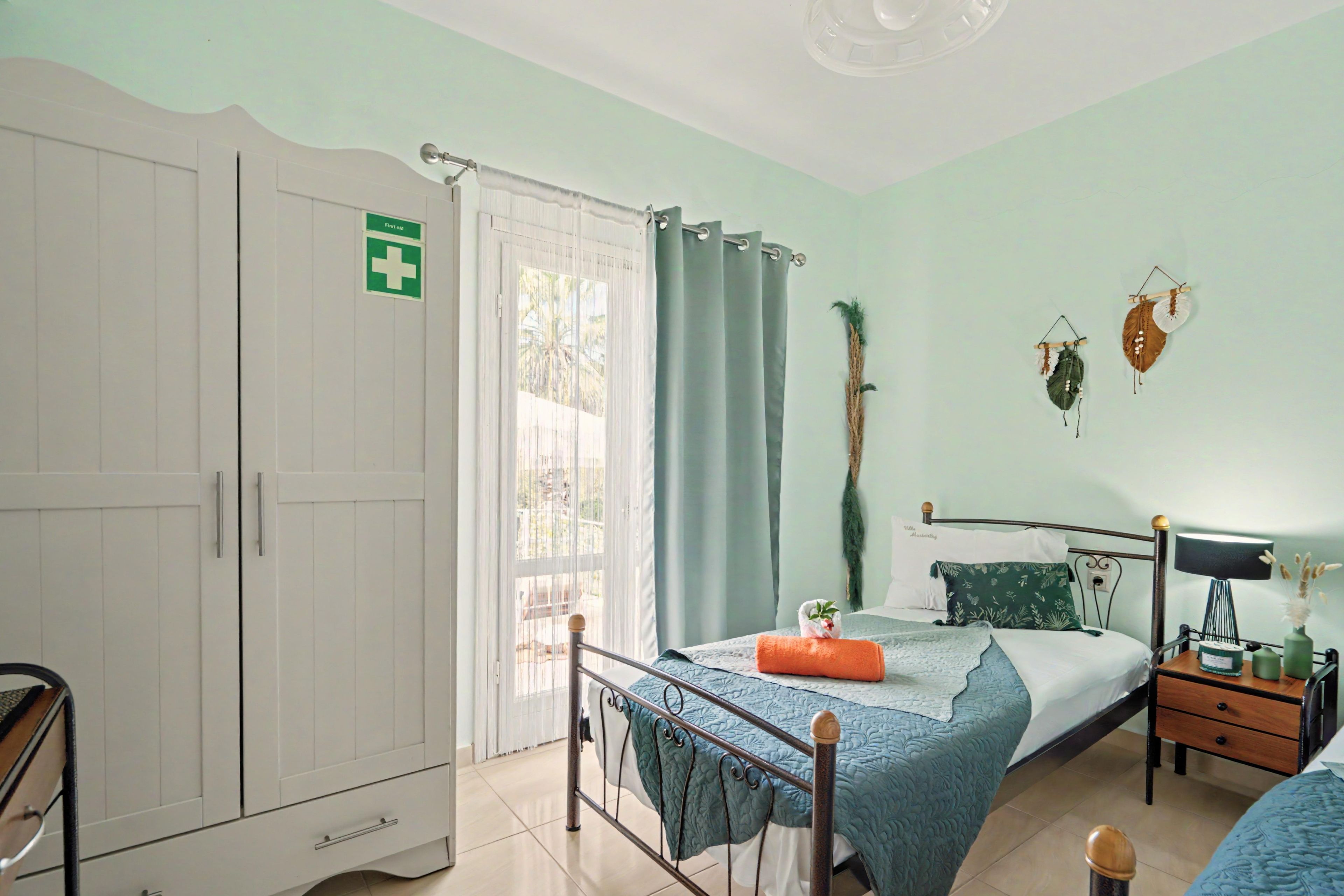 Une chambre à coucher comprenant un lit, une table de chevet, une lampe et une armoire.