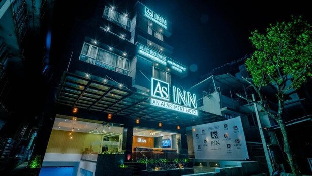 An AS INN apartment hotel with a modern design, featuring a well-lit entrance and visible balconies. - AS Inn (Kanayannur)