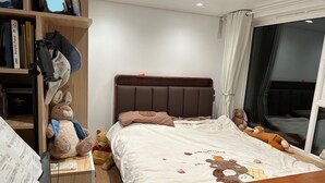 Ein Schlafzimmer mit einem Bett, einem Bücherregal und einem Fenster.