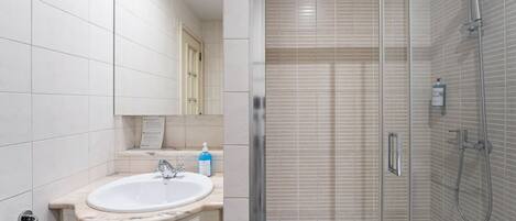 Ein modernes Badezimmer mit Waschbecken, Spiegel und Dusche.