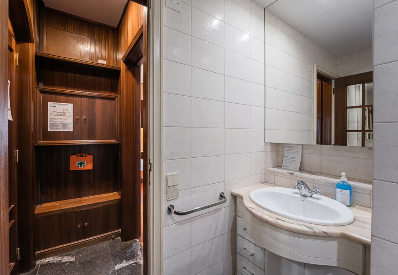 Une salle de bain avec un meuble-lavabo en bois, un lavabo blanc et un miroir.