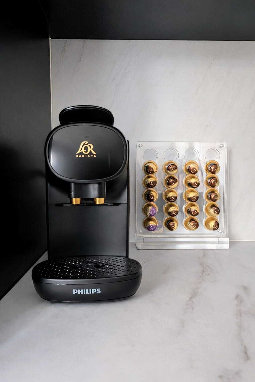 A black Philips coffee maker with a coffee pod holder containing various pods.