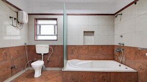 A bathroom with a toilet, bathtub, and a window. - Smart stay by- Brill rooms (Barasat)