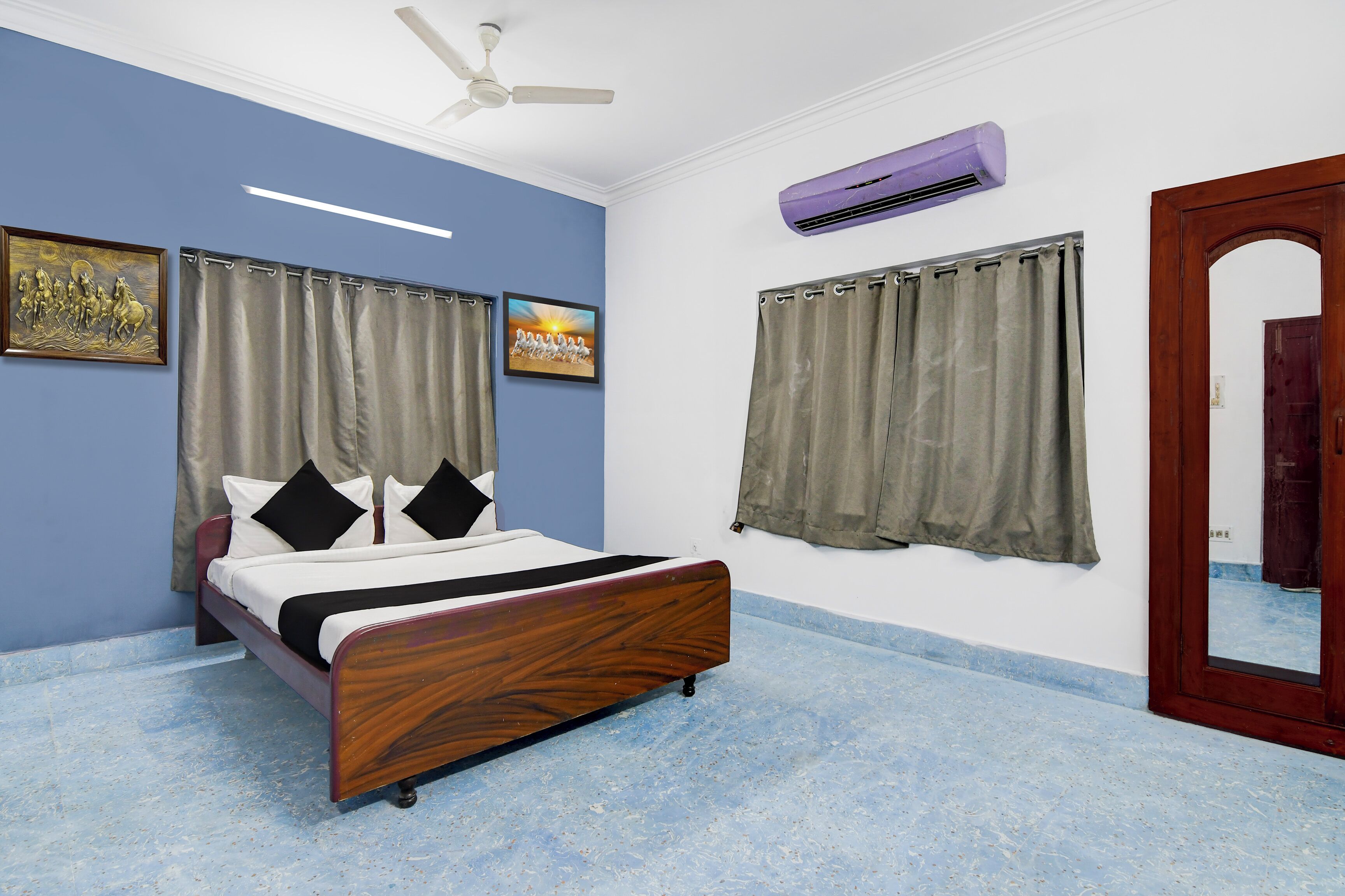Un dormitorio con cama, cortinas, ventilador de techo, aire acondicionado y espejo.