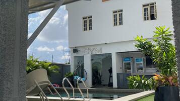 Un edificio con un cartello che riporta 'GREYFIELD APARTMENT' e un cartello per la palestra sottostante.