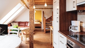 Un apartamento estilo loft acogedor, con cocina, comedor y sala de estar con sofá y escalera.