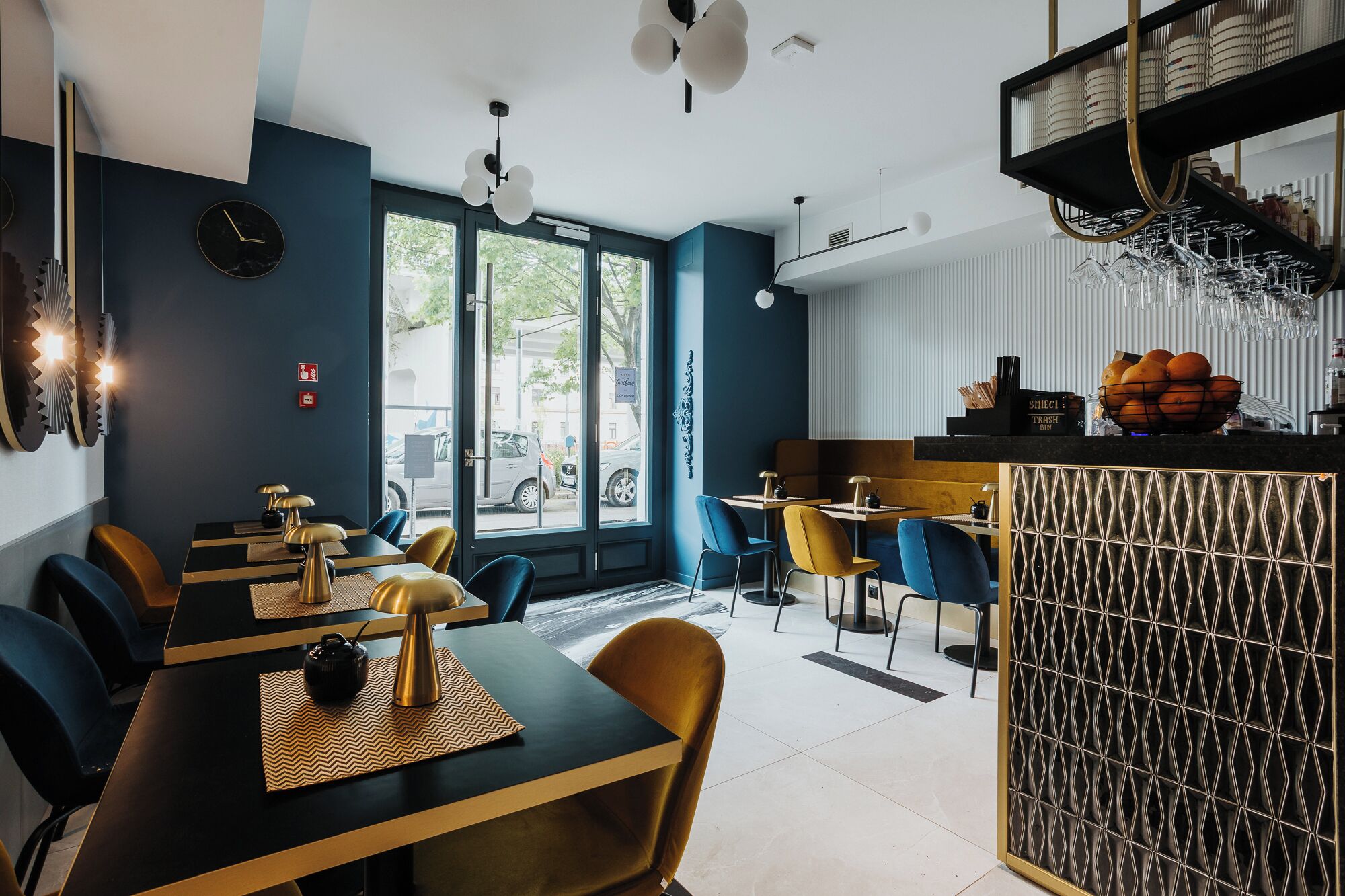 A modern restaurant interior with a bar area, dining tables, and chairs.