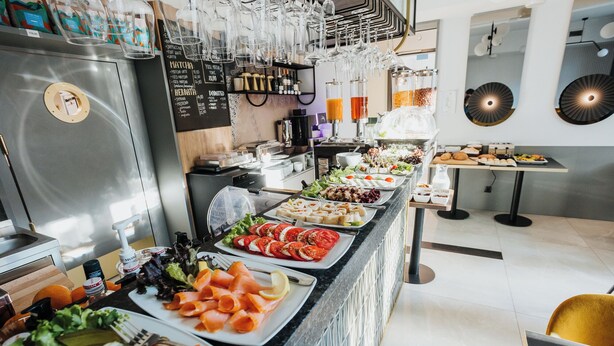 Un bufé con diversas opciones de comida, una selección de vinos y una estación de café.