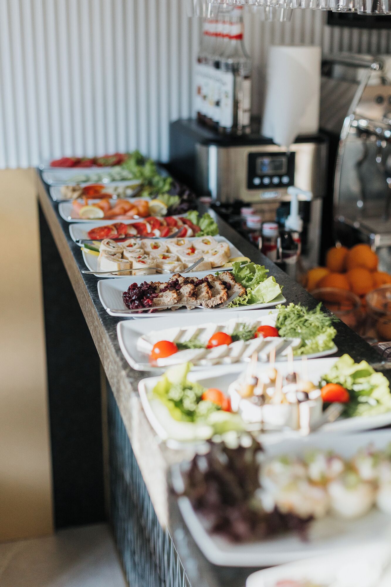 A buffet with various dishes including salads, sandwiches, and fruits.