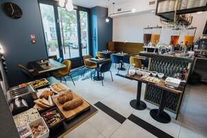Ein Café mit Tischen, Stühlen und einer Auswahl an Speisen.