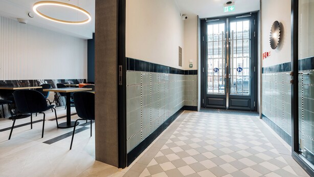 A hotel lobby with a check-in desk, seating area, and a glass door entrance. - Hotel M4 Boutique (Kraków)