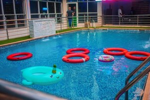 Uma piscina com vários flutuadores infláveis e um brinquedo inflável de desenho animado.
