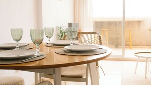 A dining table set with plates, glasses, and a chair. - Terraza Azul - Penthouse with sea view by Interhome (Alcocéber/Alcossebre)
