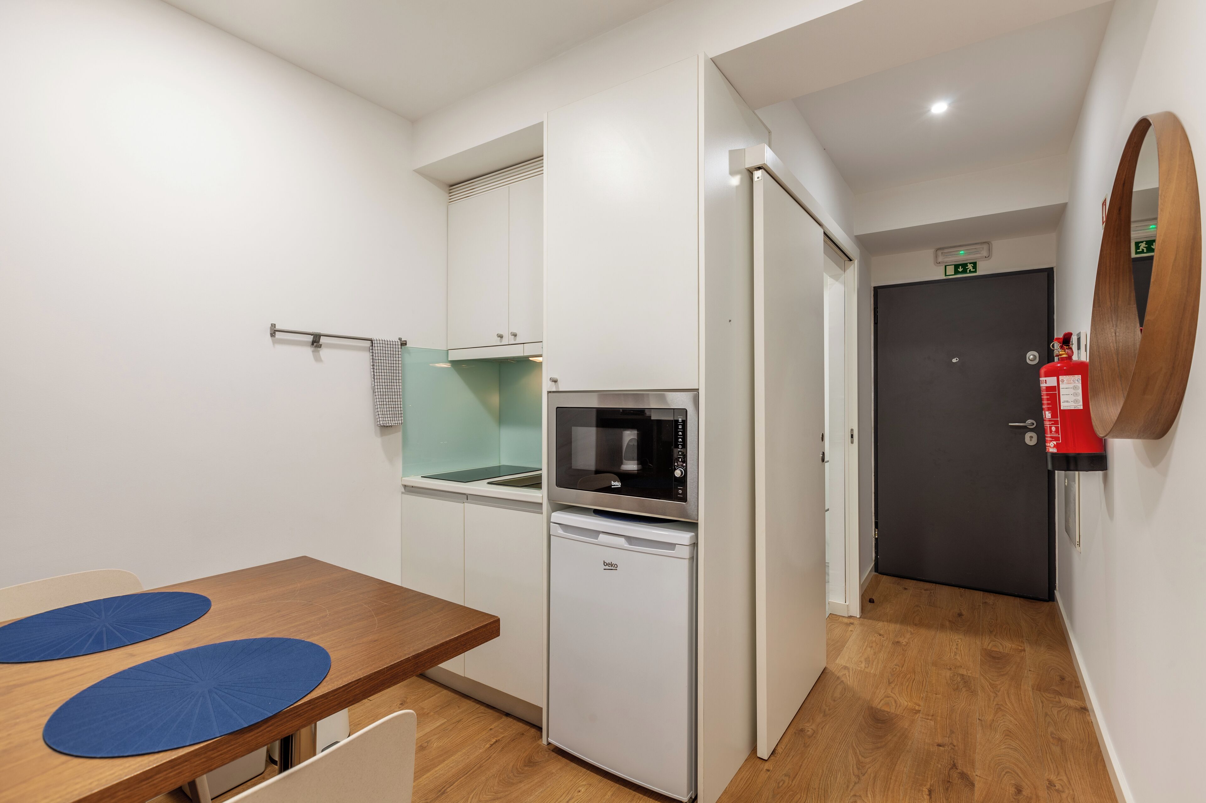 A compact kitchenette with a microwave, refrigerator, and a small sink.
