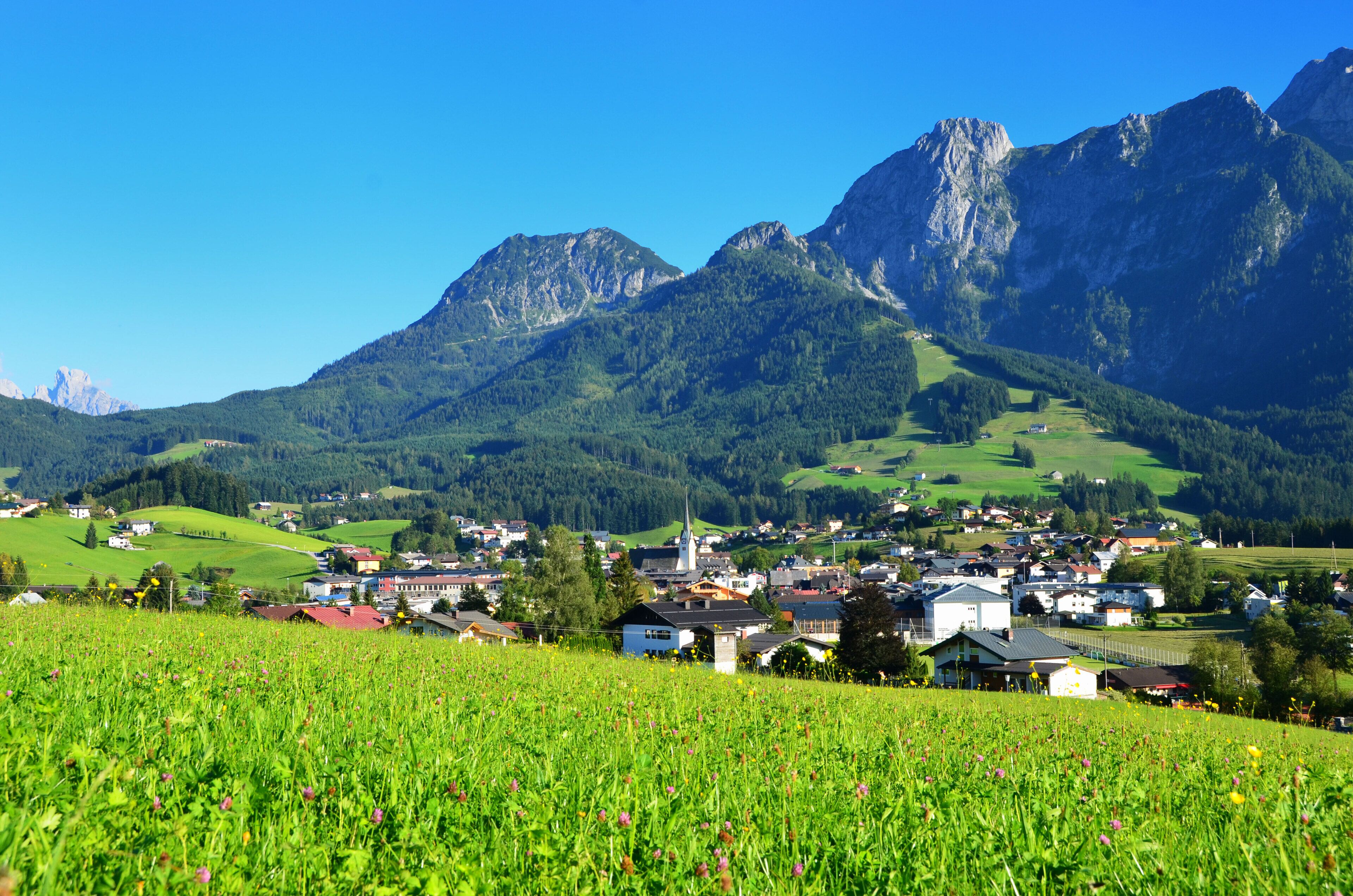 A town nestled in a valley with mountains in the background.