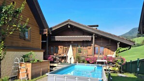 A wooden cabin with a swimming pool, a wooden deck, and a garden with flowers. - Cozy vacation home in charming nature and mountain scenery! Dogs welcome! (Abtenau)