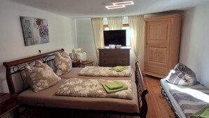 A bedroom with two beds, a dresser, a television, and a wardrobe. - Cozy vacation home in charming nature and mountain scenery! Dogs welcome! (Abtenau)
