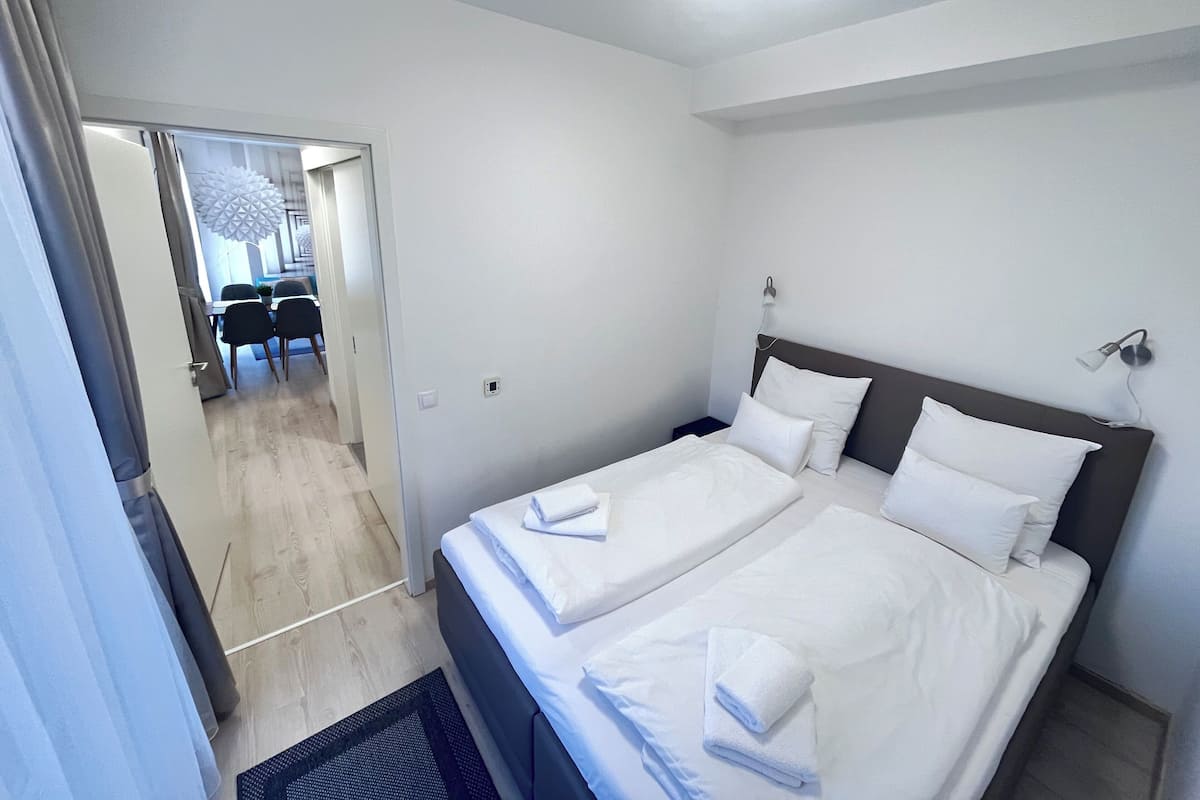 Habitación de hotel con dos camas, un escritorio y una silla.