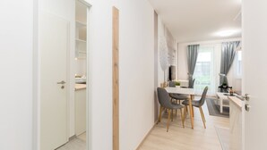 A modern kitchen with a dining area, wooden cabinets, and a view of the outdoors. - Budapest Downtown Residence LEO (Budapest)
