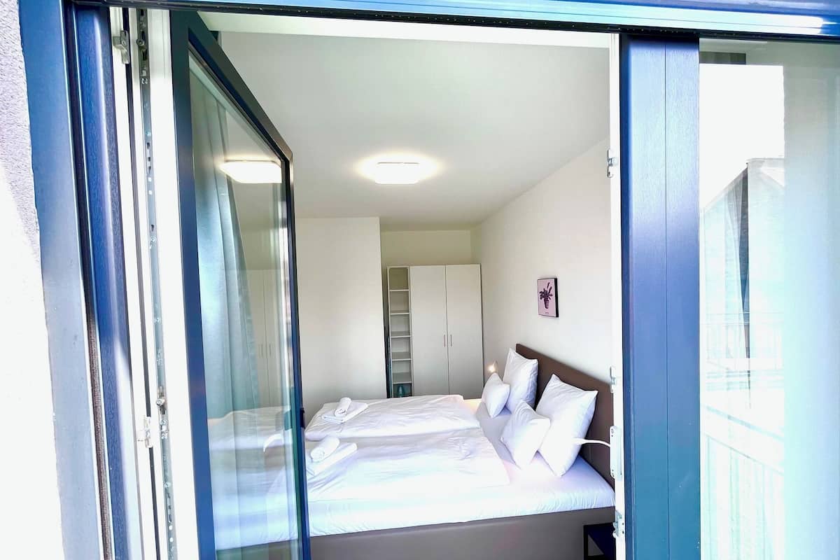 Un dormitorio con cama, armario y puerta de cristal.