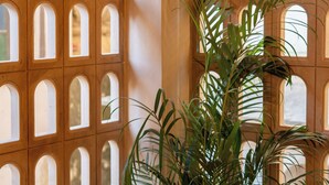 A room with a wooden lattice partition and a potted plant. - Bun And Bunks Udaipur (Udaipur)