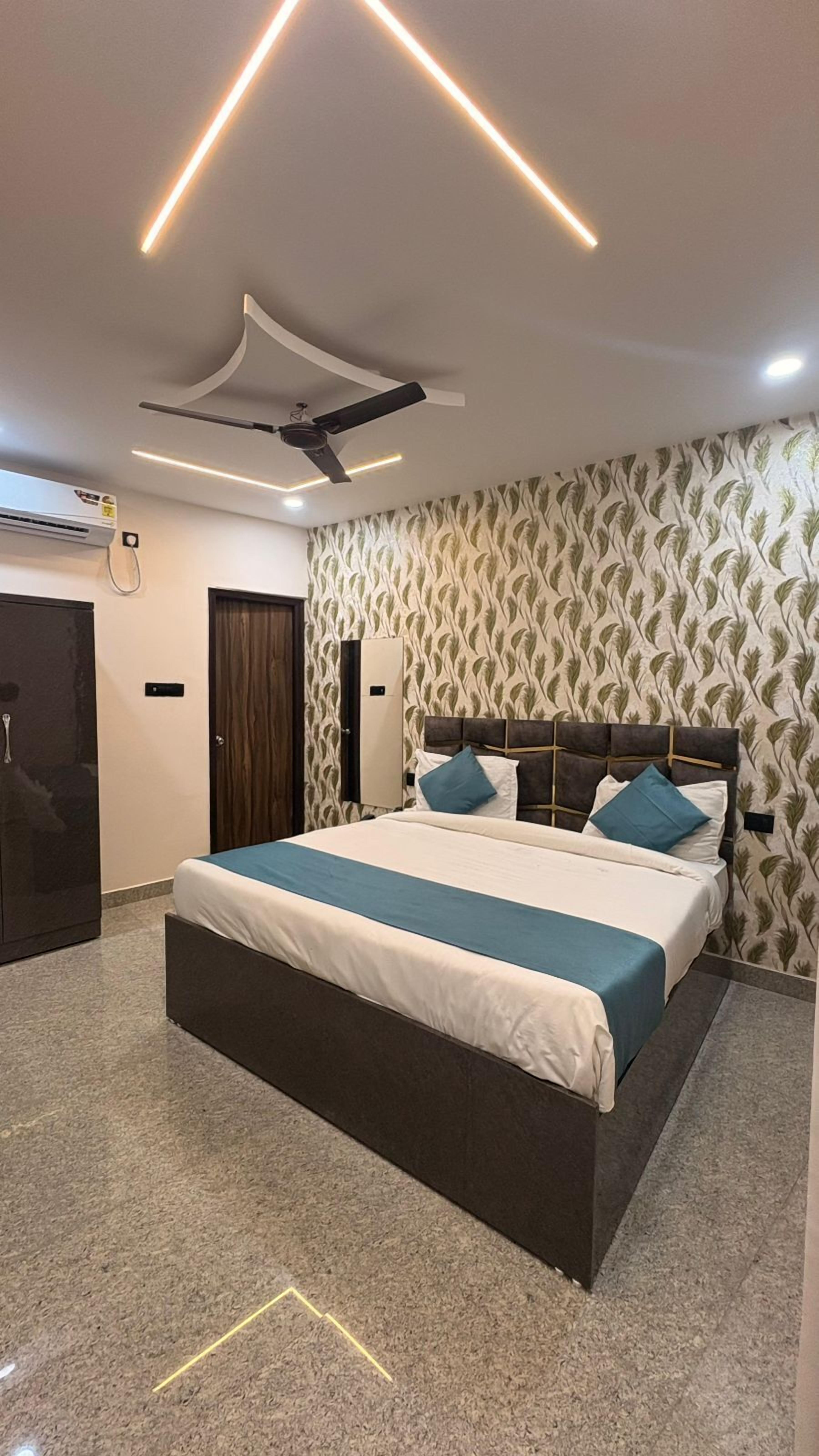 Un dormitorio moderno con una cama grande, ventilador de techo y papel tapiz estampado.