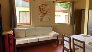A room with a sofa, a dining table, and a painting on the wall. - CASA DENISE ILE SAINTE MARIE VOHILAVA MADA New fully-equipped house with garden (sainte marie - ambodifotatra)