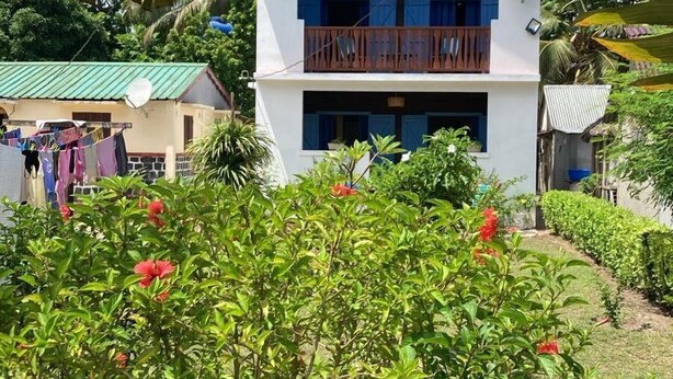 A two-story building with a blue roof and a sign reading 'Casa Denise.' - CASA DENISE ILE SAINTE MARIE VOHILAVA MADA New fully-equipped house with garden (sainte marie - ambodifotatra)