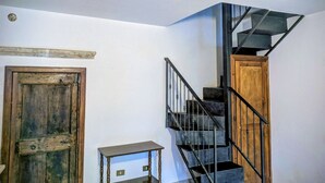 Una escalera con una puerta de madera y una pequeña mesa.